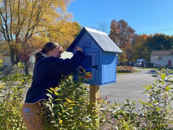 Loreley works on installing the Little Free Library at Senior Center