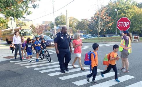 Chief Newport helps schoolchildren at crosswalk.